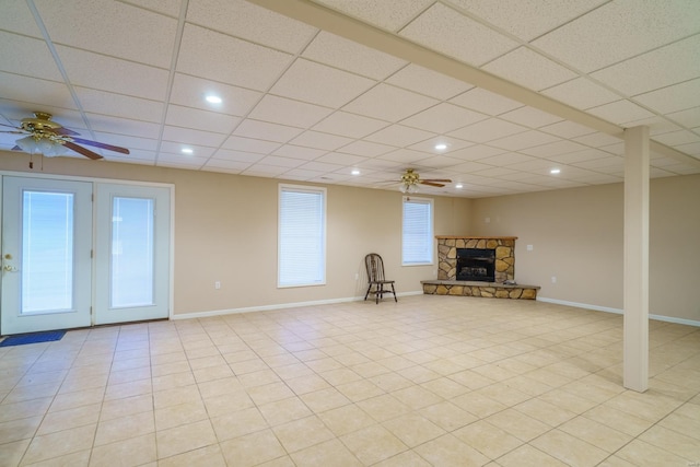 unfurnished living room with a paneled ceiling, ceiling fan, and a fireplace