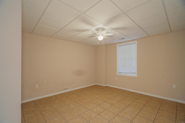 spare room with ceiling fan, a drop ceiling, and light tile patterned floors