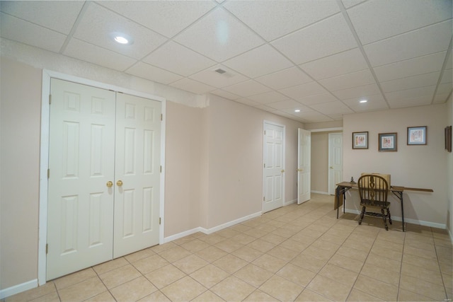 unfurnished office with light tile patterned floors and a drop ceiling