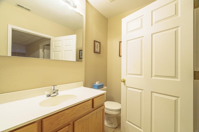 bathroom with tile patterned flooring, vanity, and toilet