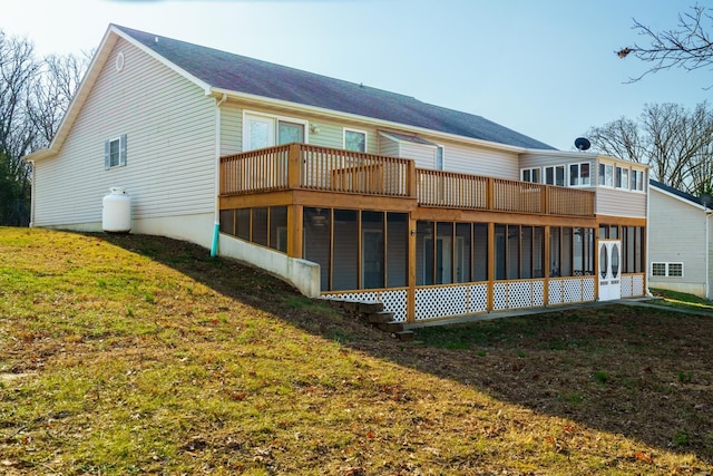 back of property featuring a sunroom and a lawn