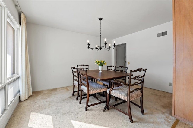 dining space with light colored carpet, visible vents, plenty of natural light, and an inviting chandelier