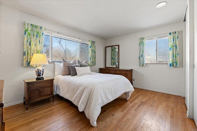 bedroom featuring baseboards and light wood finished floors