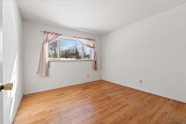 spare room with light wood-type flooring and baseboards