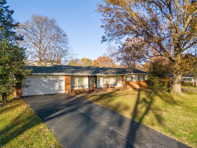 ranch-style home with an attached garage, brick siding, driveway, and a front yard