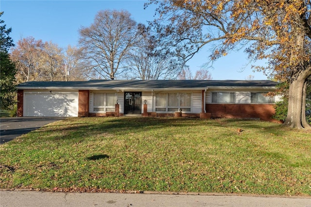 single story home with aphalt driveway, brick siding, an attached garage, and a front lawn