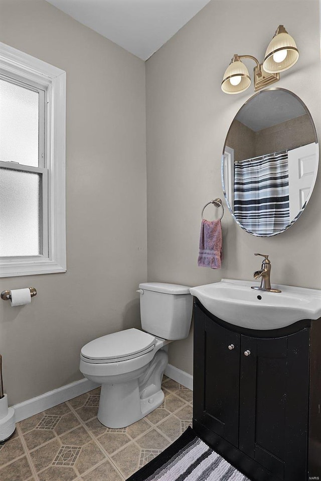 bathroom with toilet, tile patterned flooring, and vanity