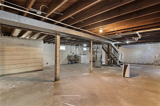 basement featuring heating unit and washing machine and clothes dryer