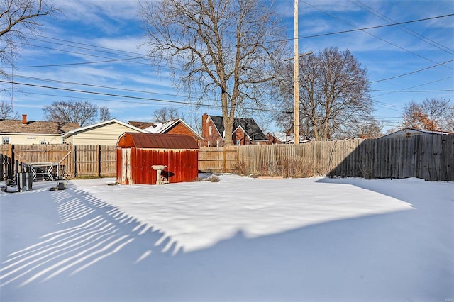 yard covered in snow with a storage unit