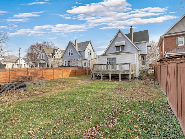 rear view of house featuring a yard and a deck