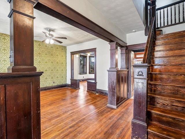 staircase featuring ornate columns, ceiling fan, and hardwood / wood-style floors