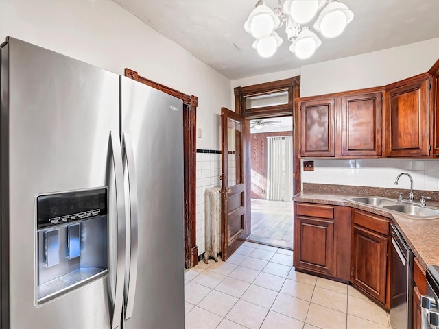 kitchen featuring sink, light tile patterned floors, stainless steel appliances, and ceiling fan with notable chandelier