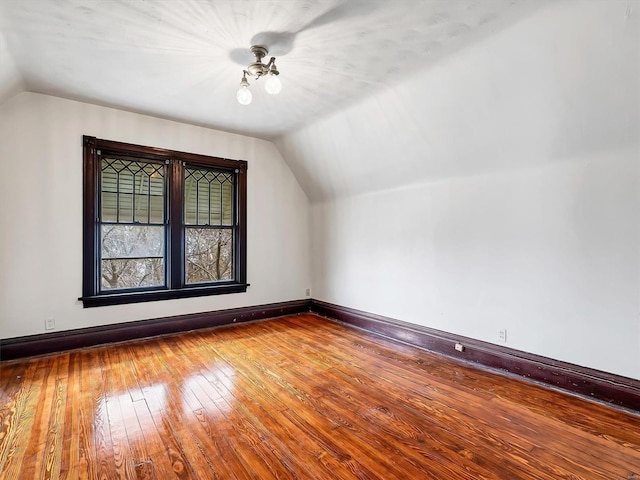 bonus room with hardwood / wood-style flooring and vaulted ceiling