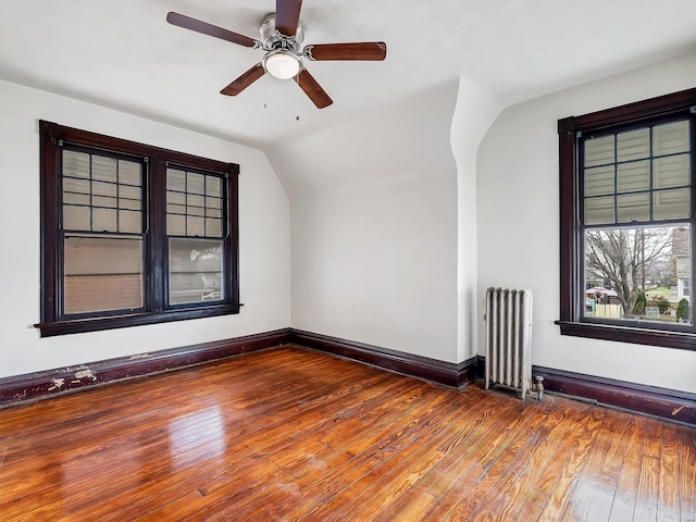 spare room with hardwood / wood-style floors, lofted ceiling, ceiling fan, and radiator heating unit