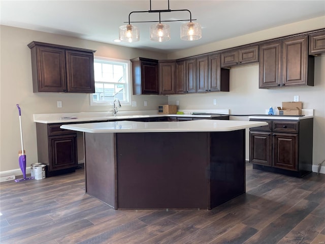 kitchen featuring dark brown cabinetry, decorative light fixtures, and dark wood-type flooring