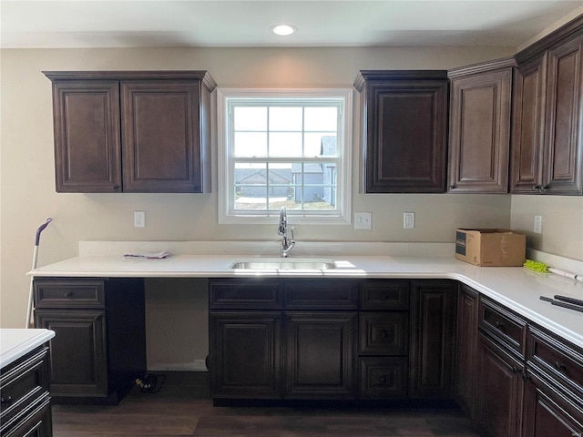 kitchen with dark brown cabinets, dark hardwood / wood-style floors, and sink