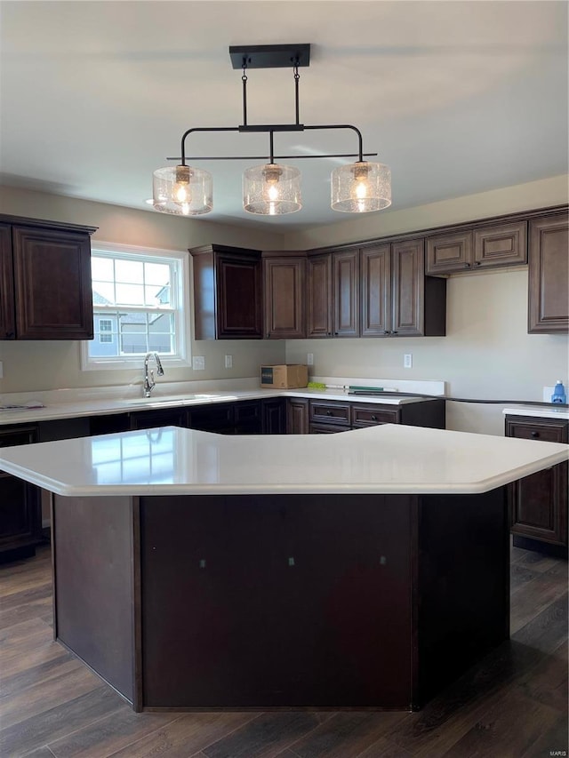 kitchen featuring dark brown cabinetry, dark hardwood / wood-style flooring, and decorative light fixtures