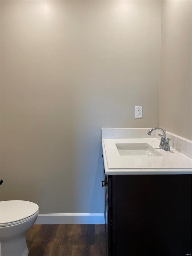 bathroom with vanity, toilet, and wood-type flooring