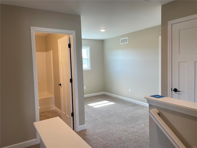 hallway featuring light carpet