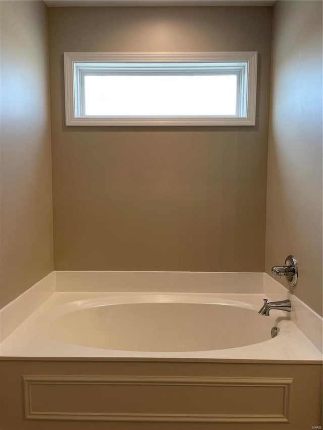 bathroom featuring plenty of natural light and a bath