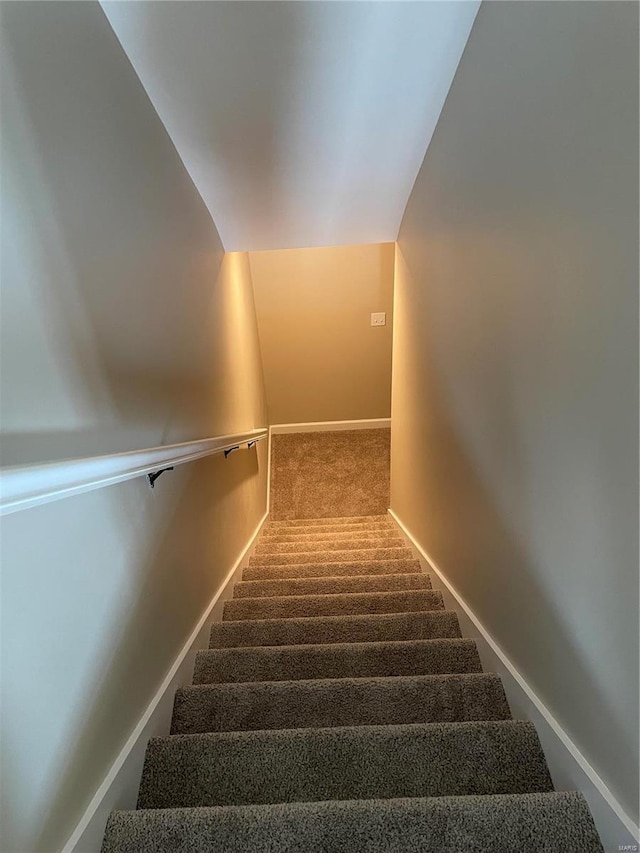 staircase with carpet and vaulted ceiling