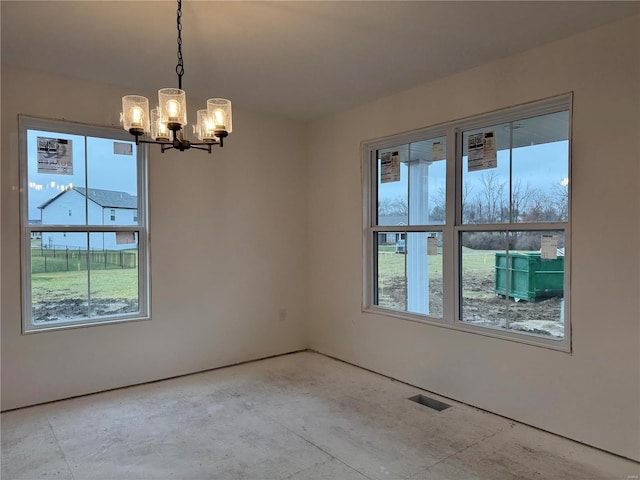 spare room featuring an inviting chandelier and plenty of natural light