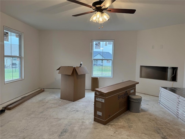 unfurnished office with a baseboard radiator, a wealth of natural light, and ceiling fan