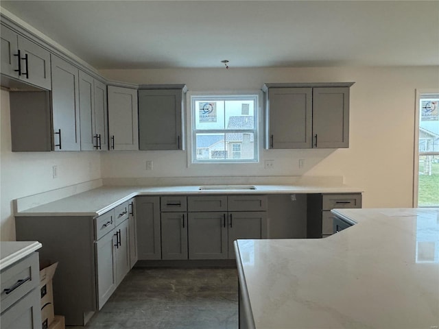 kitchen featuring plenty of natural light, gray cabinetry, and light stone counters