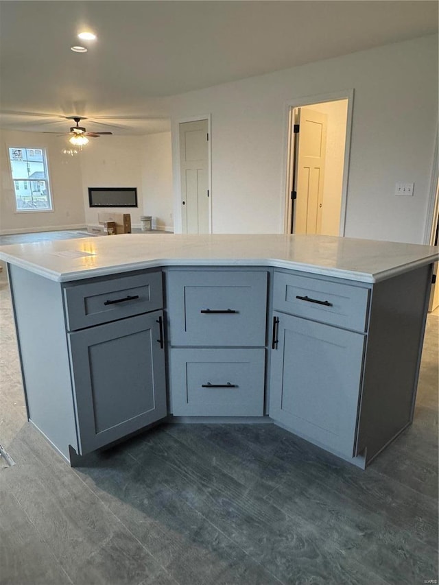 kitchen with ceiling fan, gray cabinets, and a kitchen island