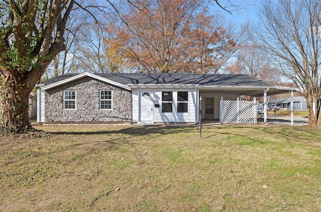 back of house with a carport and a lawn