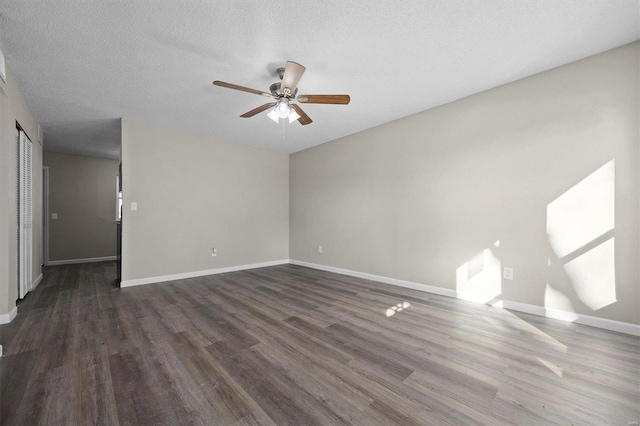 empty room featuring ceiling fan, dark hardwood / wood-style flooring, and a textured ceiling