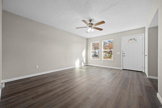 interior space featuring a textured ceiling, ceiling fan, and dark wood-type flooring