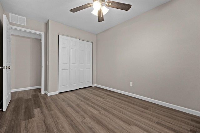 unfurnished bedroom with ceiling fan, dark hardwood / wood-style flooring, and a closet