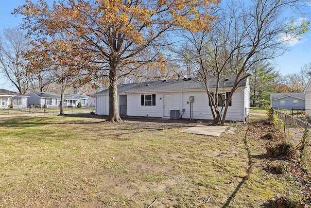 rear view of property featuring a yard and cooling unit