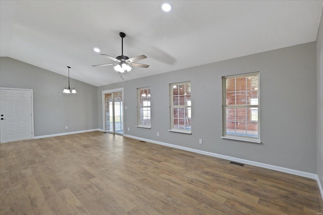 unfurnished room featuring plenty of natural light, hardwood / wood-style floors, and lofted ceiling