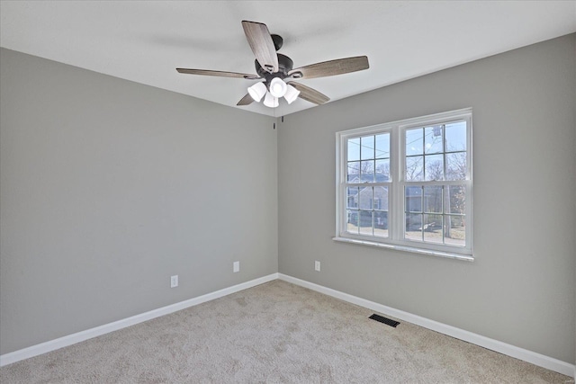 empty room featuring ceiling fan and light carpet