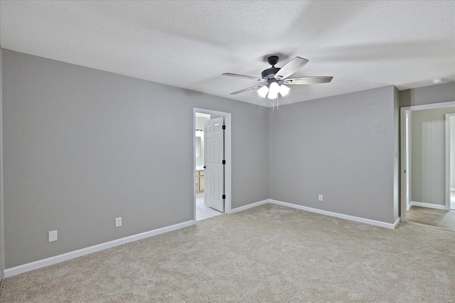 empty room with a textured ceiling, ceiling fan, and light carpet