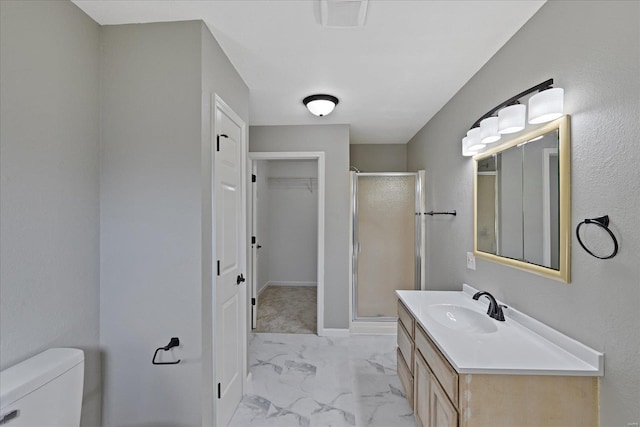 bathroom featuring vanity, toilet, and a shower with shower door