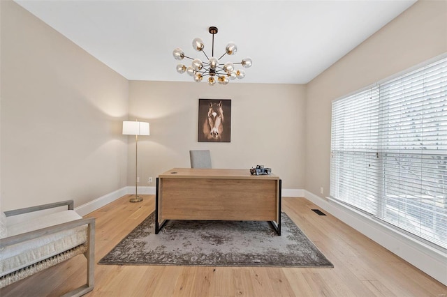 office space with a notable chandelier and light hardwood / wood-style floors