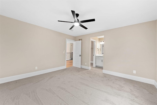 unfurnished bedroom featuring ensuite bathroom, ceiling fan, and light colored carpet