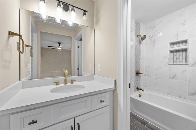 bathroom featuring ceiling fan, vanity, and tiled shower / bath