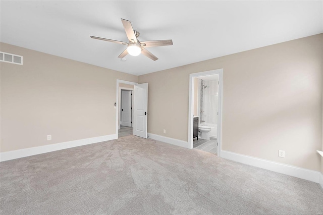 unfurnished bedroom with connected bathroom, light colored carpet, and ceiling fan