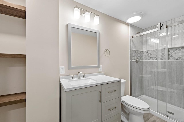 bathroom with hardwood / wood-style flooring, vanity, toilet, and an enclosed shower