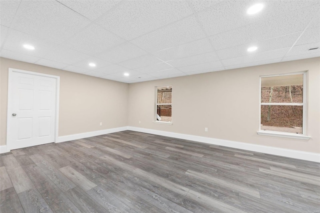 basement featuring hardwood / wood-style flooring and a paneled ceiling