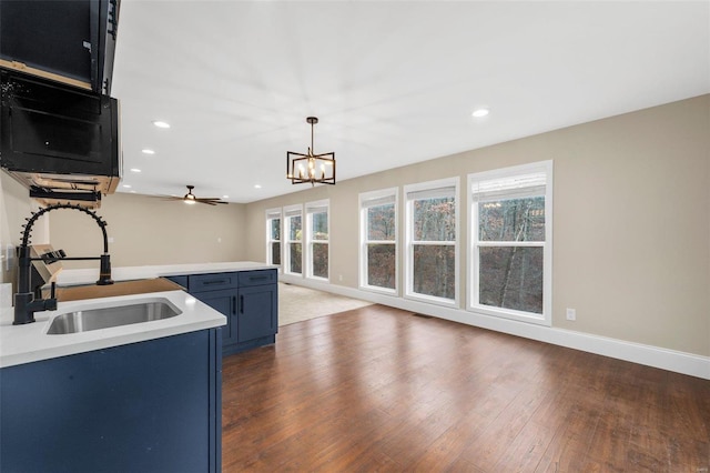 kitchen featuring a wealth of natural light, sink, pendant lighting, and blue cabinets