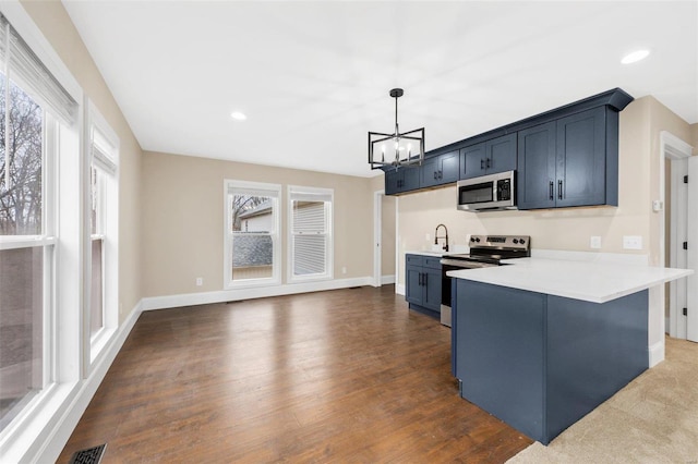 kitchen featuring sink, stainless steel appliances, a chandelier, decorative light fixtures, and a breakfast bar area