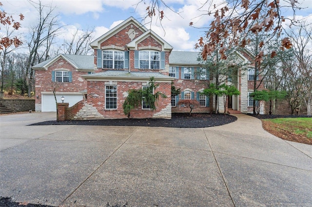 view of front of property featuring brick siding, an attached garage, and driveway