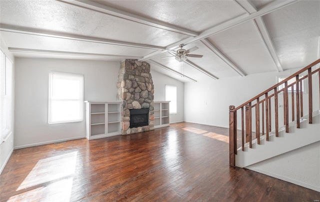 unfurnished living room with lofted ceiling with beams, dark hardwood / wood-style floors, and plenty of natural light