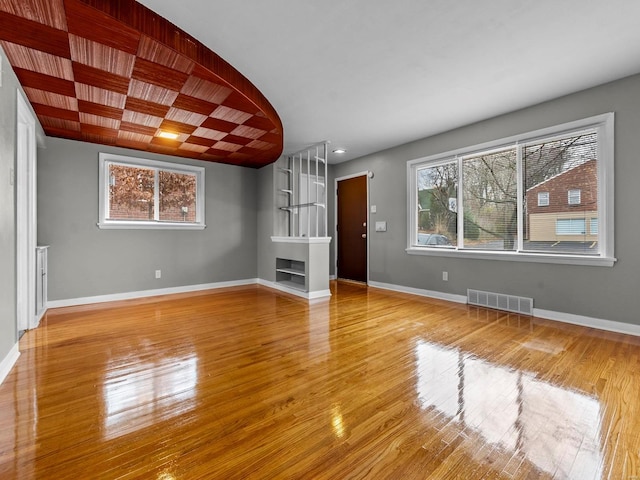 unfurnished living room featuring hardwood / wood-style flooring and plenty of natural light