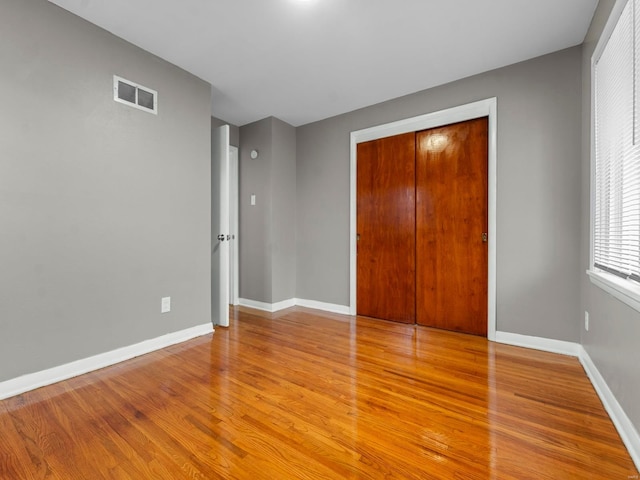 unfurnished bedroom with light hardwood / wood-style flooring and a closet